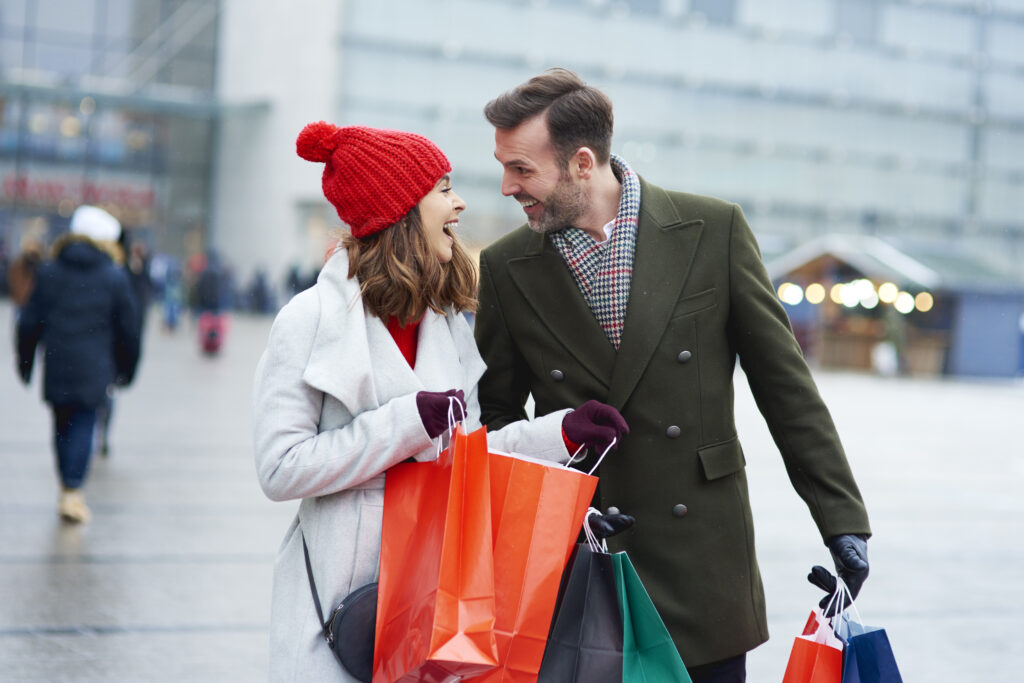 happy couple shopping looking at each other as they are walking