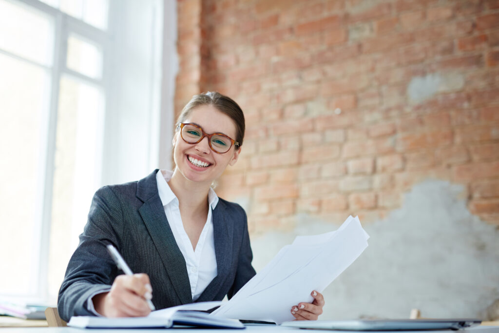 Woman smiling whilst working on some important documents