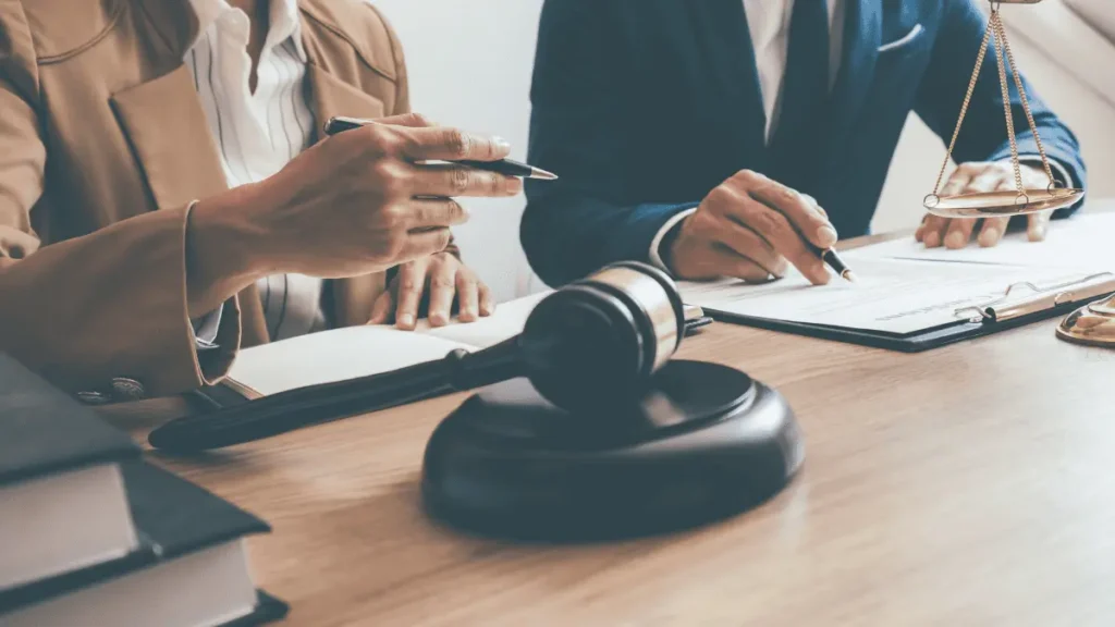 A man and woman sat at a desk with a gavel and documents for Joint and Several Liability